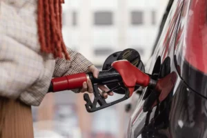 close up woman gas station in red choosing oil and gas RON 92