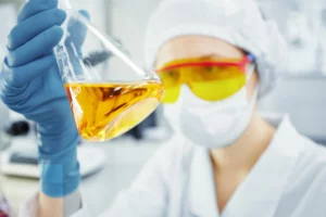 female researcher with safety glasses and hair net doing science experiments